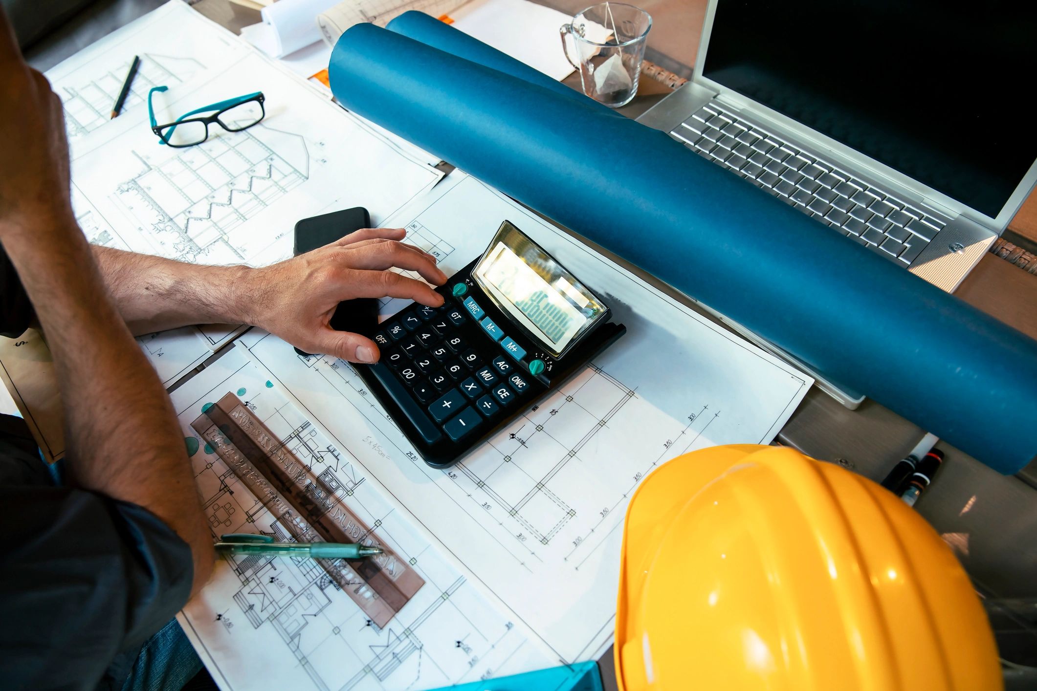 Unrecognizable Architect calculating and working on project.